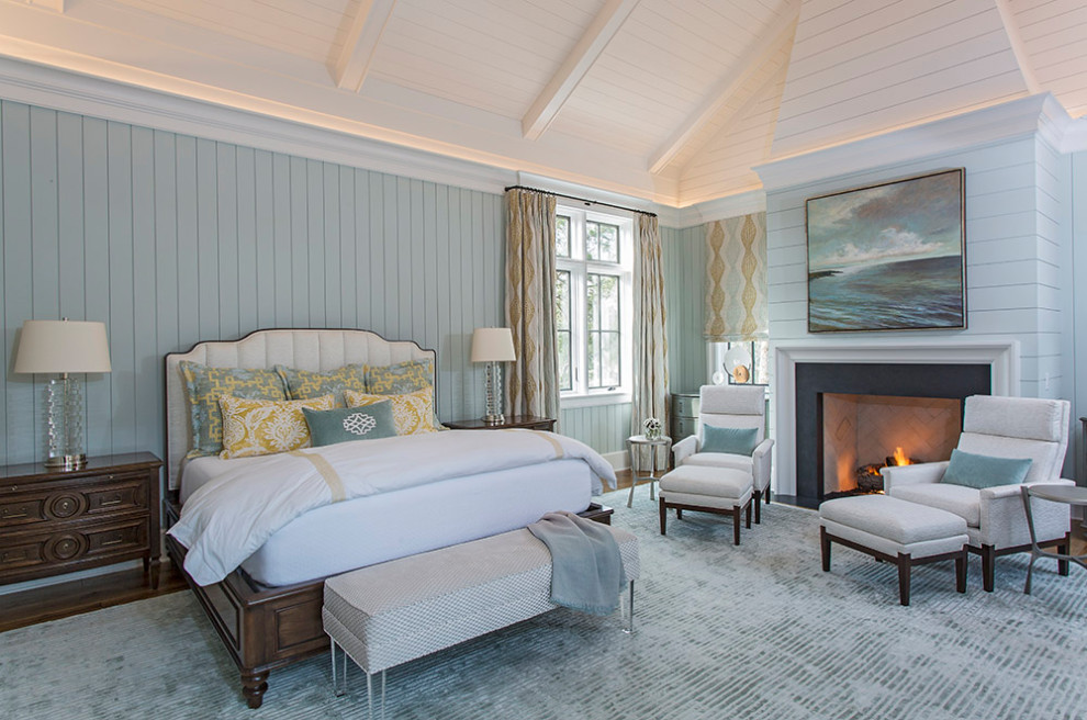 Maritimes Schlafzimmer mit blauer Wandfarbe, Kamin, gewölbter Decke und Holzdielenwänden in Charleston