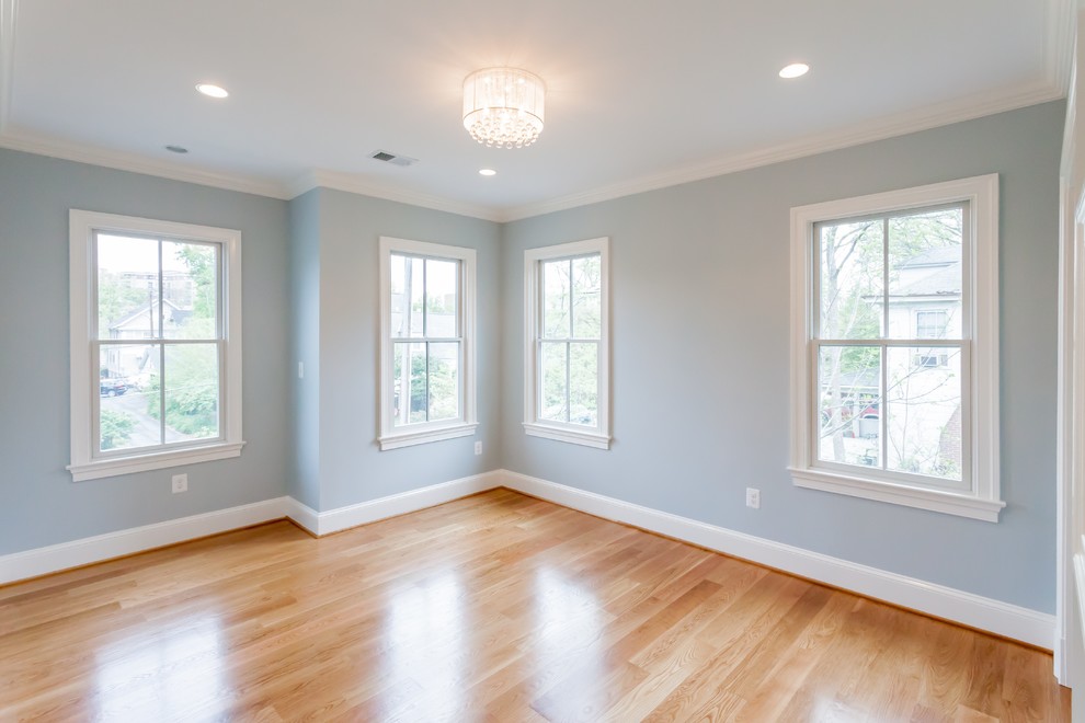 Imagen de habitación de invitados campestre sin chimenea con paredes azules, suelo de madera clara y suelo marrón