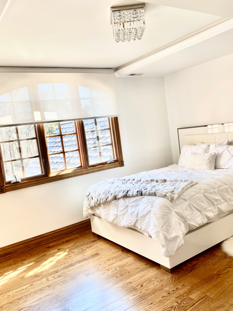 Modelo de habitación de invitados minimalista grande sin chimenea con paredes blancas, suelo de madera en tonos medios, suelo marrón y casetón