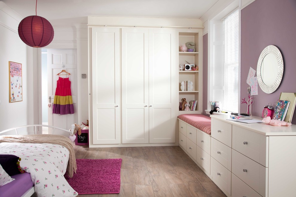 Mittelgroßes Modernes Schlafzimmer mit lila Wandfarbe und braunem Holzboden in West Midlands
