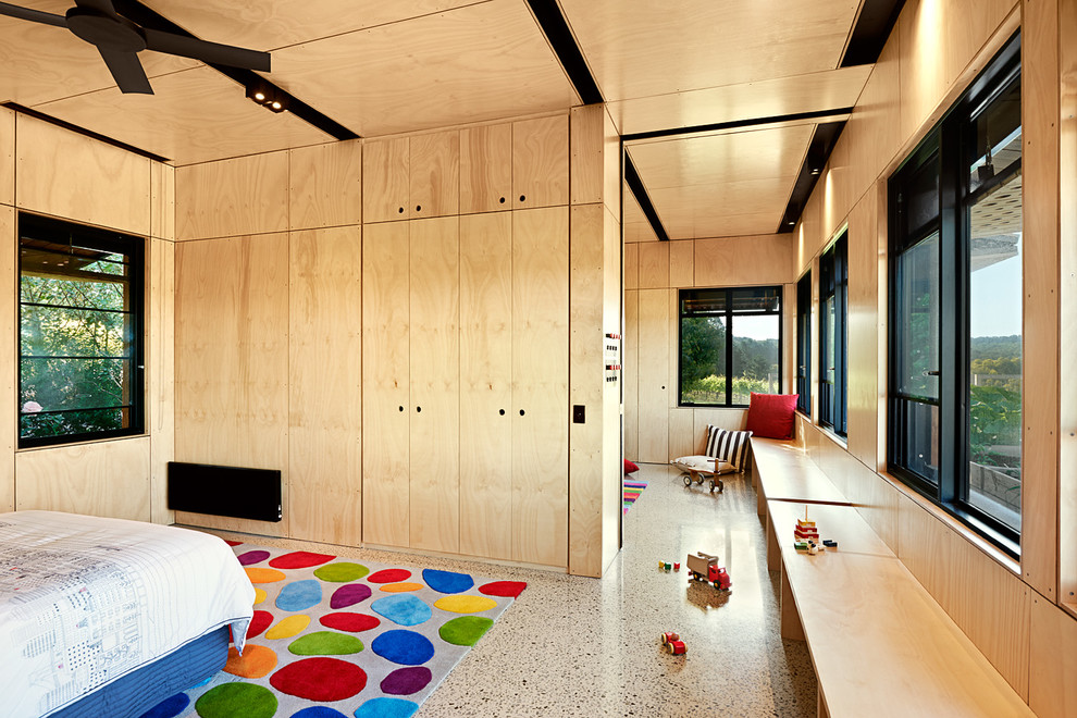 На фото: большая гостевая спальня (комната для гостей) в современном стиле с бежевыми стенами и бетонным полом без камина