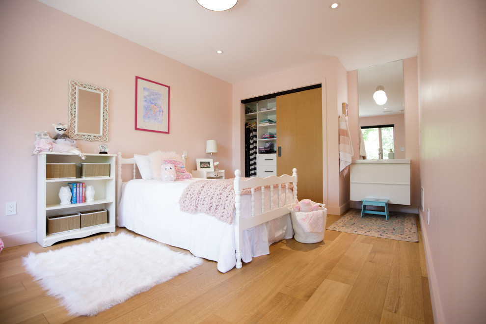 Imagen de habitación de invitados actual de tamaño medio con paredes rosas y suelo de madera en tonos medios