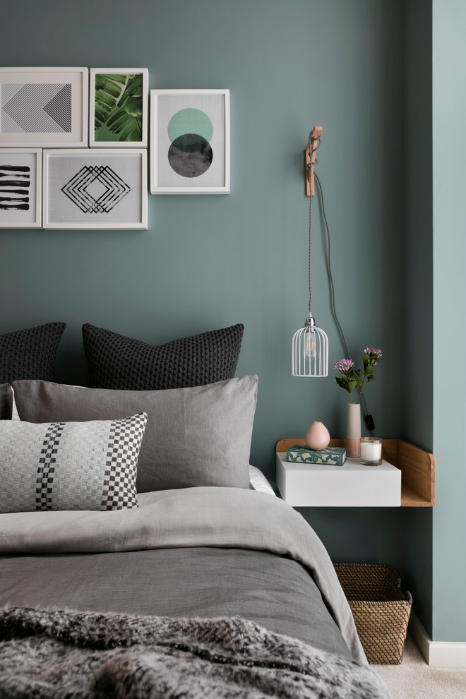 Example of a danish carpeted bedroom design in London with green walls