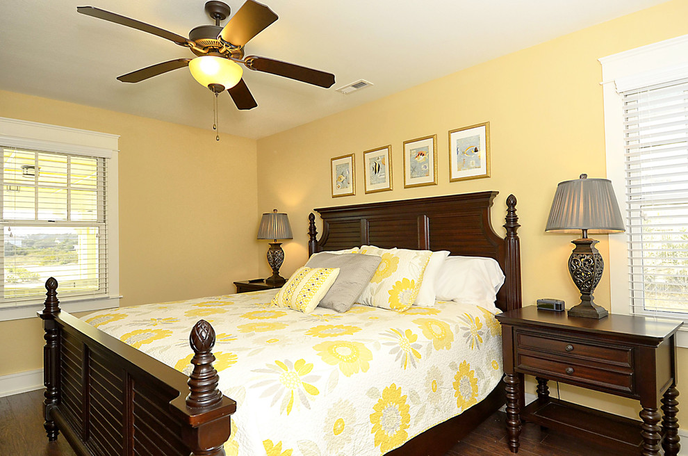 Modelo de habitación de invitados marinera de tamaño medio sin chimenea con paredes amarillas y suelo de madera oscura