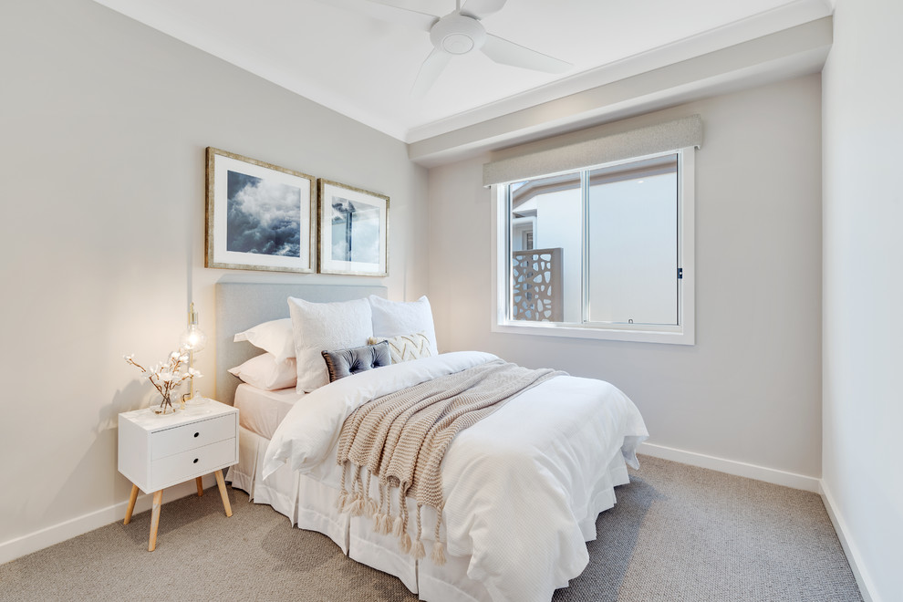 Foto de habitación de invitados costera con paredes grises, moqueta y suelo beige