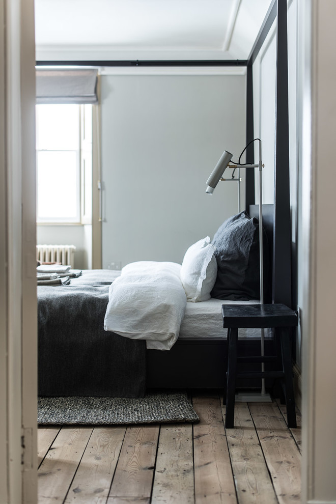 エディンバラにある中くらいな北欧スタイルのおしゃれな主寝室 (グレーの壁、無垢フローリング)