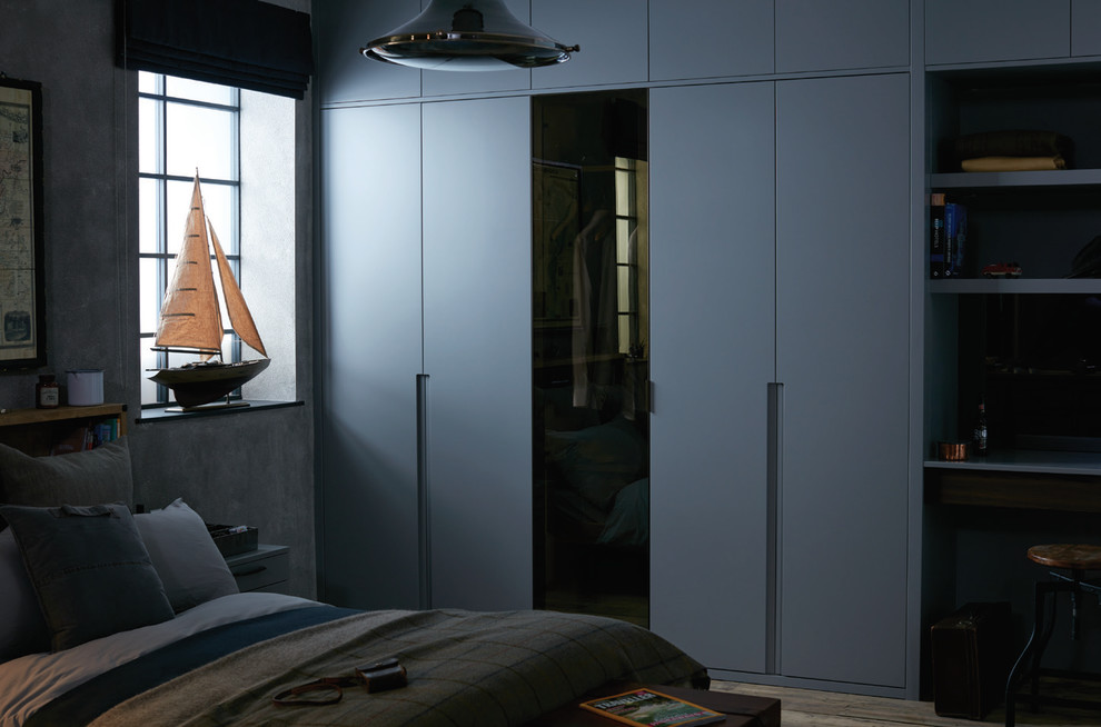 Стильный дизайн: хозяйская спальня среднего размера в современном стиле с серыми стенами, деревянным полом и фасадом камина из камня без камина - последний тренд