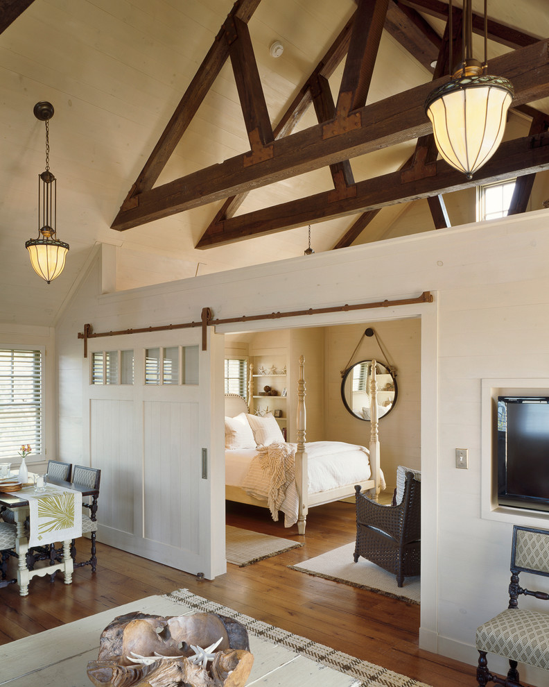 Immagine di una camera da letto costiera con pareti beige e pavimento in legno massello medio