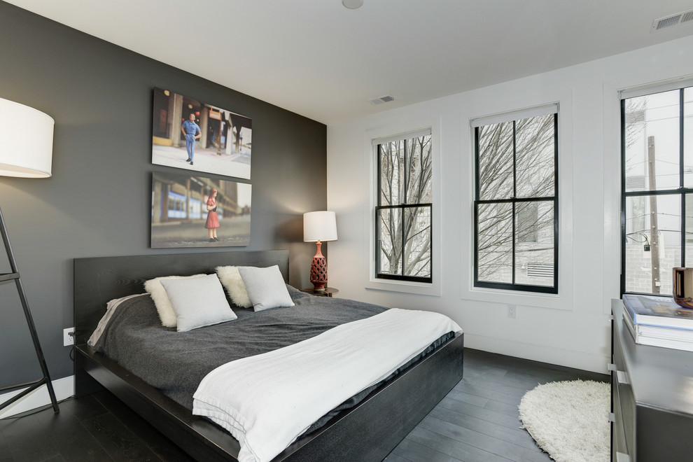 Imagen de dormitorio principal moderno sin chimenea con paredes blancas, suelo de madera oscura y suelo negro