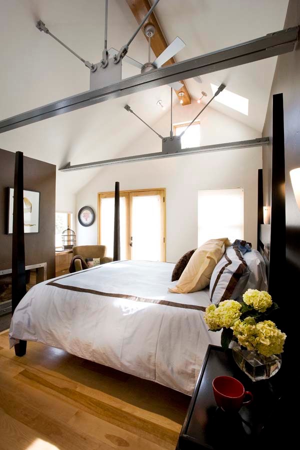 Inspiration for a large industrial master medium tone wood floor and brown floor bedroom remodel in Salt Lake City with white walls and a standard fireplace