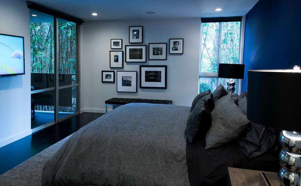 Großes Modernes Hauptschlafzimmer mit blauer Wandfarbe, dunklem Holzboden und schwarzem Boden in Los Angeles
