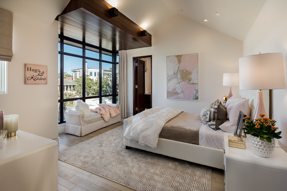 Photo of a traditional bedroom in Orange County with white walls and medium hardwood flooring.