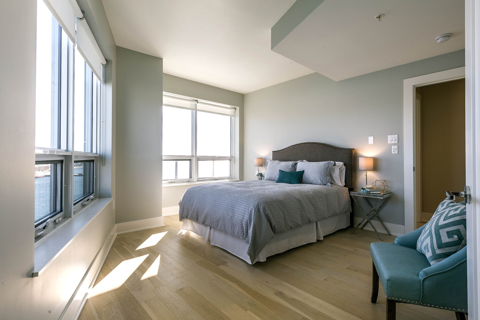 Design ideas for a small contemporary master bedroom in Other with beige walls and light hardwood flooring.