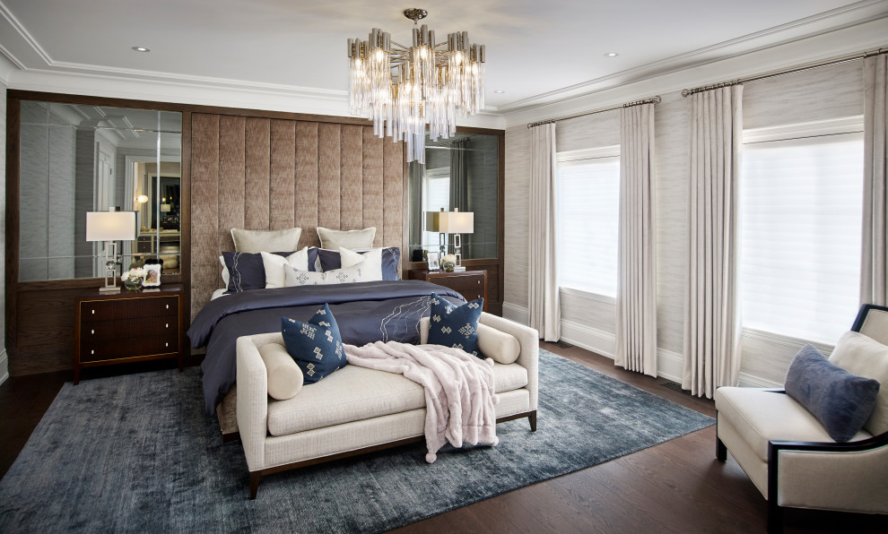 Modelo de dormitorio principal clásico renovado grande con paredes beige, suelo de madera oscura, suelo marrón y papel pintado