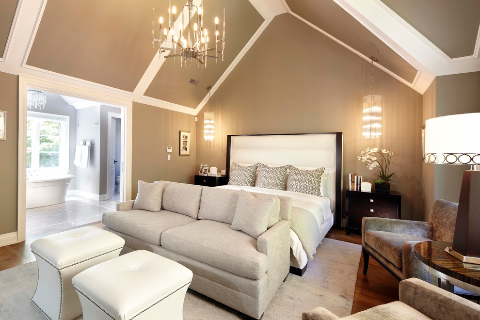 Modelo de dormitorio principal tradicional renovado grande con suelo de madera en tonos medios y paredes grises