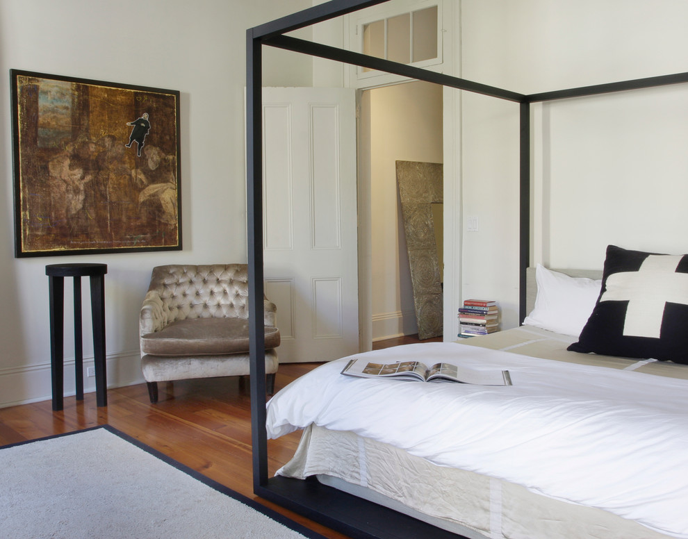 Modernes Schlafzimmer mit weißer Wandfarbe und braunem Holzboden in New Orleans