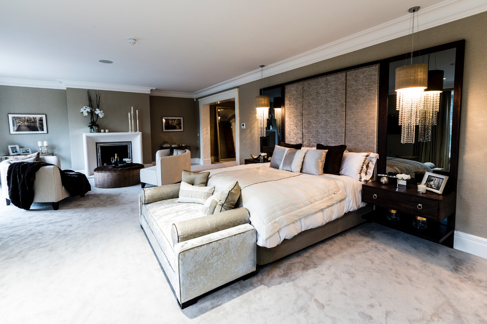 На фото: хозяйская спальня в современном стиле с серыми стенами, ковровым покрытием и стандартным камином с