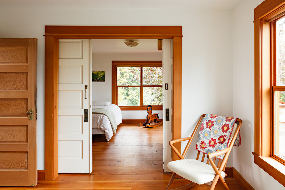 Immagine di una camera da letto stile americano con pavimento in legno massello medio