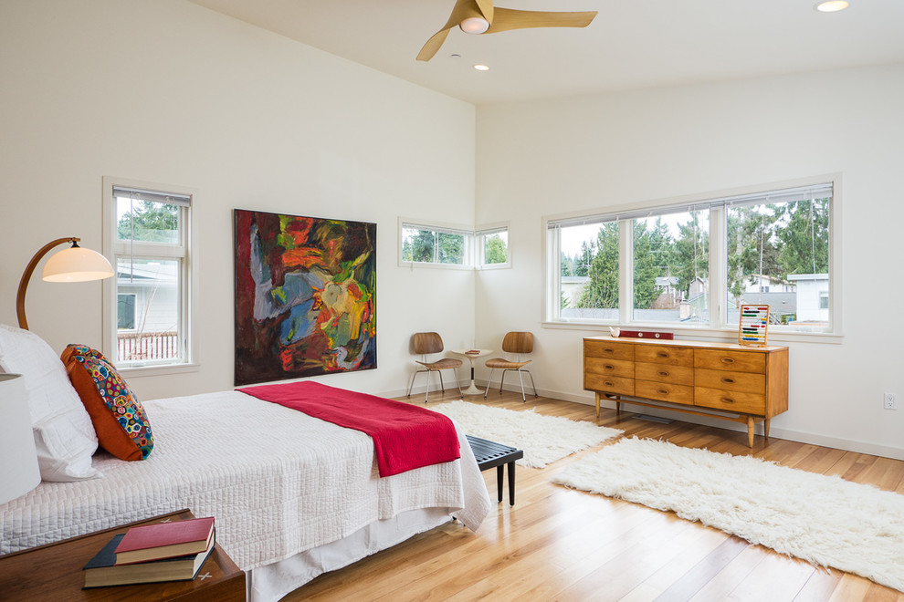 Diseño de dormitorio retro con paredes blancas y suelo de madera en tonos medios