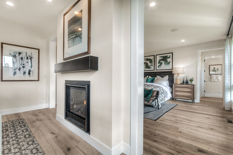Transitional master light wood floor bedroom photo in Seattle with white walls and a two-sided fireplace