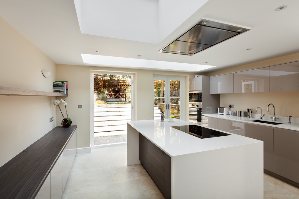 Immagine di un cucina con isola centrale minimal di medie dimensioni con top in superficie solida, elettrodomestici da incasso e pavimento con piastrelle in ceramica