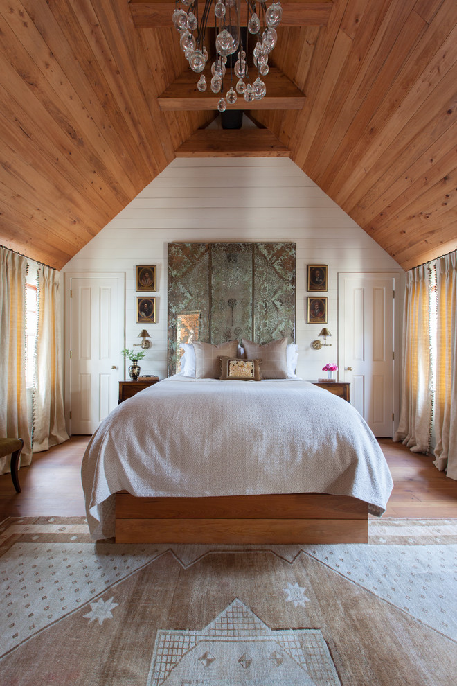 Bild på ett lantligt sovrum, med vita väggar, mellanmörkt trägolv och brunt golv