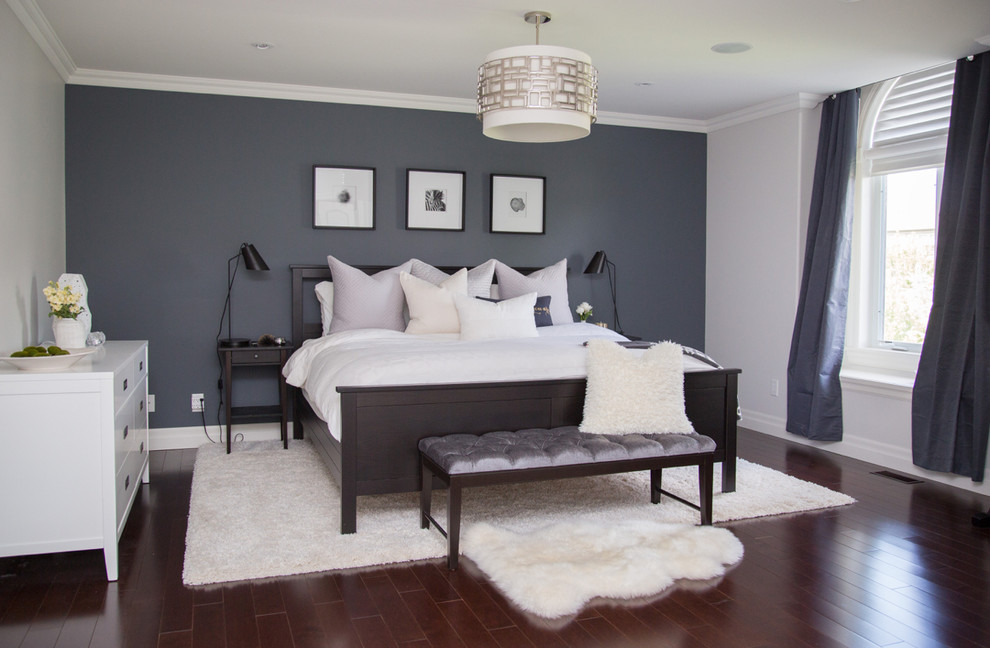 Example of a large eclectic master medium tone wood floor bedroom design in Toronto with no fireplace and gray walls