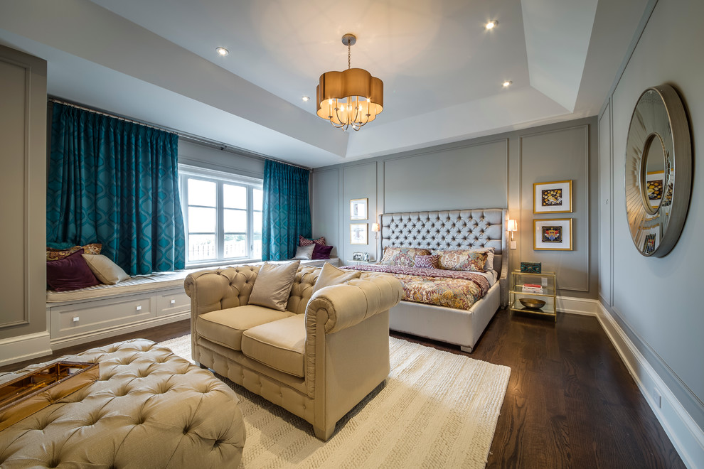 トロントにある広いトランジショナルスタイルのおしゃれな主寝室 (グレーの壁、無垢フローリング、石材の暖炉まわり、青いカーテン)