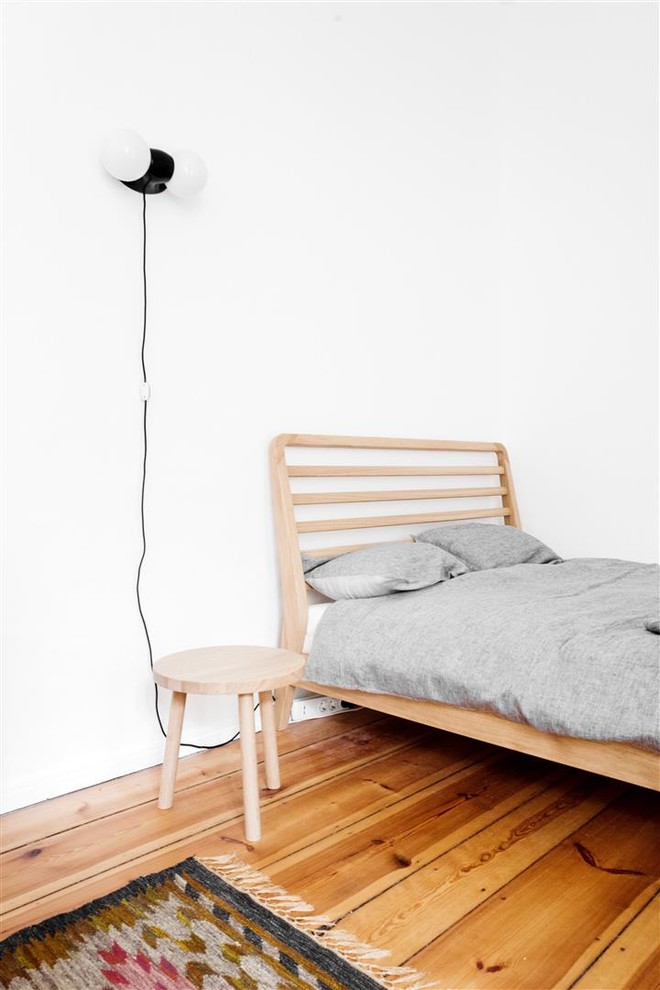 Kleines Mid-Century Schlafzimmer im Loft-Style mit weißer Wandfarbe und hellem Holzboden in Berlin