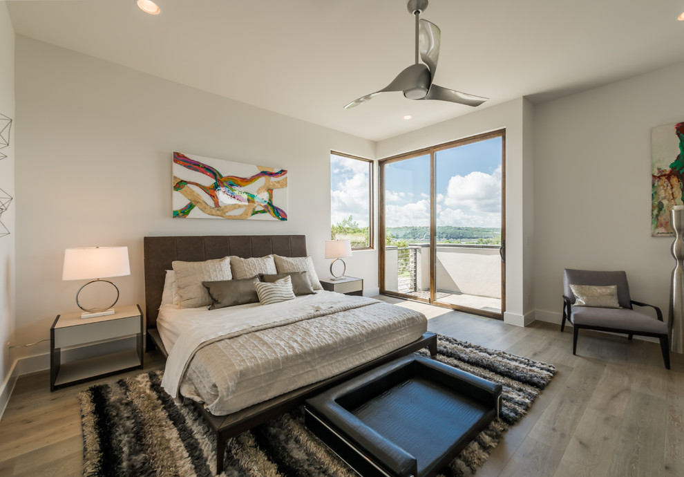 Großes Modernes Hauptschlafzimmer ohne Kamin mit weißer Wandfarbe und dunklem Holzboden in Austin
