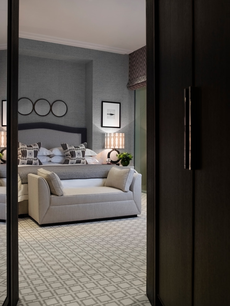 This is an example of a large contemporary guest bedroom in London with grey walls, carpet, no fireplace and brown floors.
