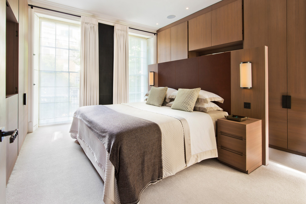 Photo of a contemporary master bedroom in London with carpet, no fireplace and beige floors.