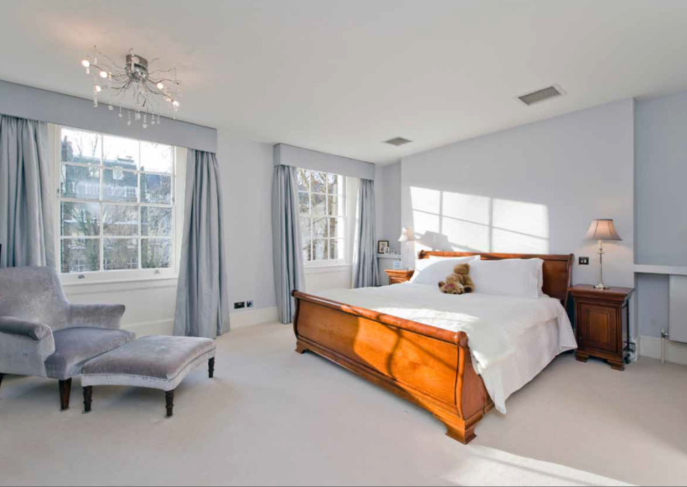 Стильный дизайн: хозяйская спальня среднего размера в современном стиле с синими стенами, ковровым покрытием, печью-буржуйкой, фасадом камина из дерева и синим полом - последний тренд