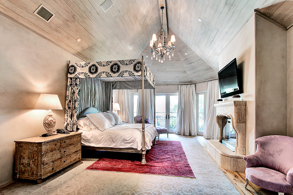 Foto de dormitorio actual con paredes beige, suelo de madera en tonos medios, todas las chimeneas y marco de chimenea de piedra
