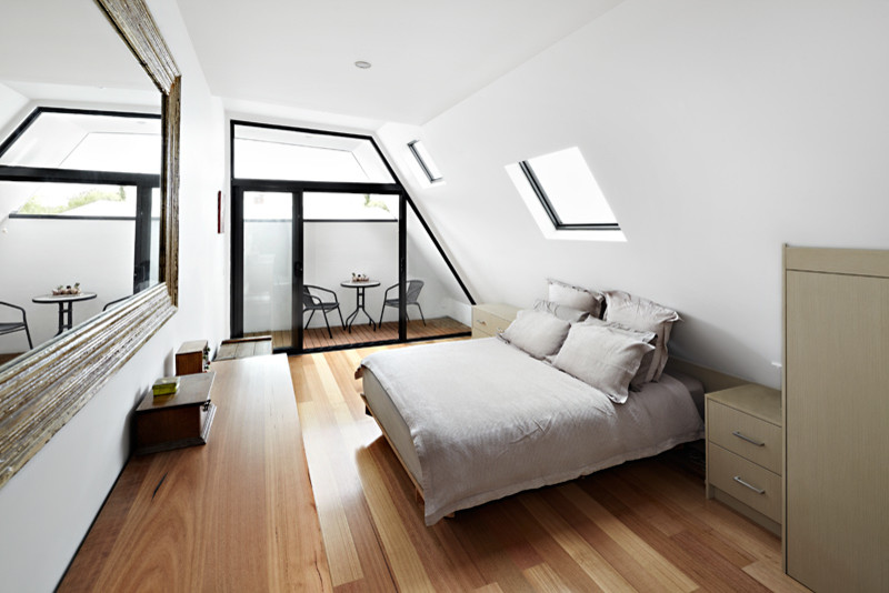Réalisation d'une petite chambre parentale design avec un mur blanc et un sol en bois brun.