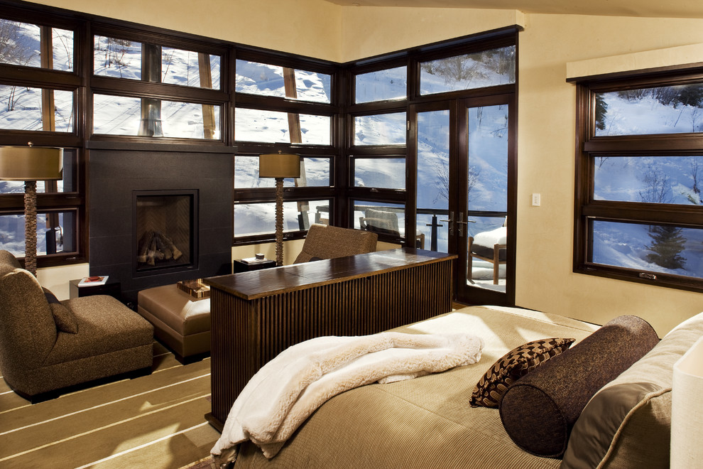 This is an example of a contemporary bedroom in Denver with beige walls and a standard fireplace.