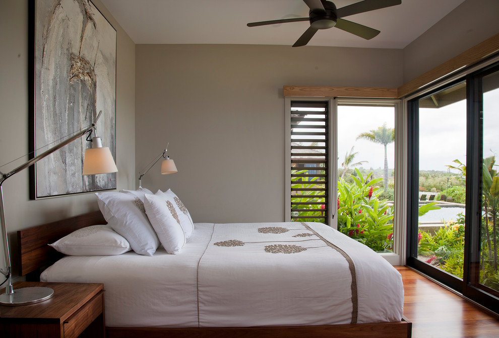 ハワイにあるトロピカルスタイルのおしゃれな寝室 (グレーの壁) のインテリア