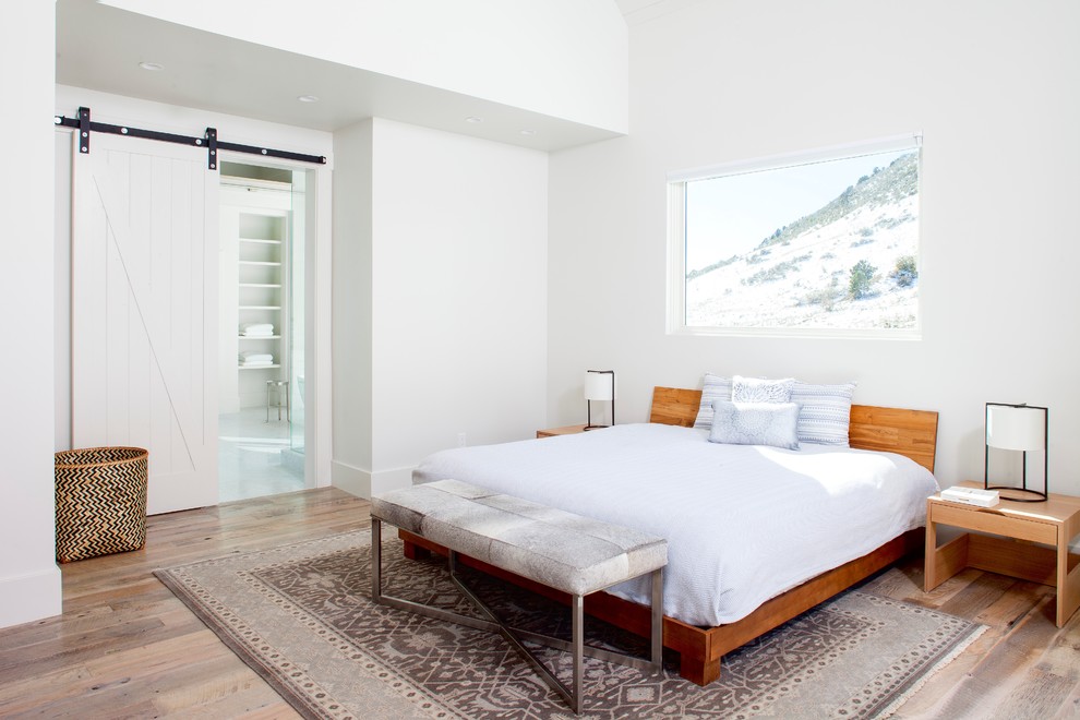 Foto de dormitorio principal campestre con paredes blancas, suelo de madera en tonos medios y suelo marrón