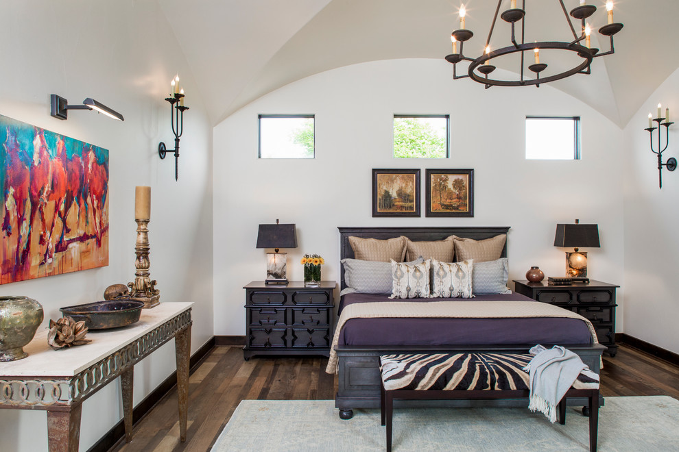 Inspiration for a mediterranean bedroom in Austin with white walls and dark hardwood flooring.