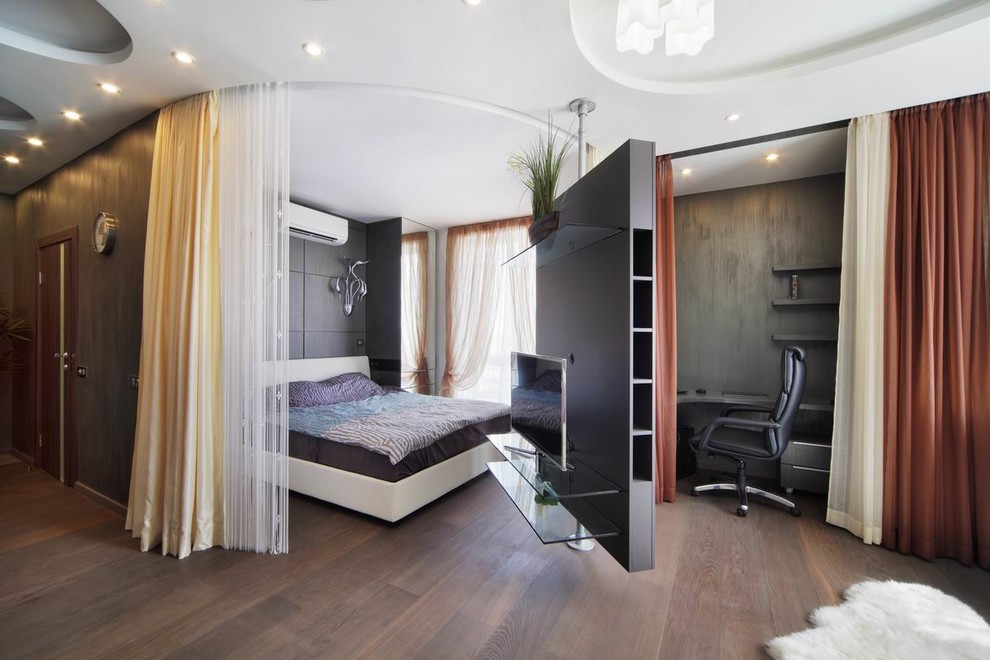 Ejemplo de dormitorio principal y televisión actual pequeño con paredes negras, suelo de madera en tonos medios y suelo marrón