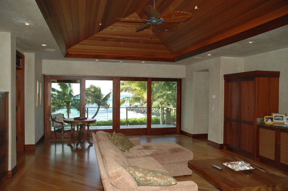 Ispirazione per una camera matrimoniale tropicale con pavimento in legno massello medio