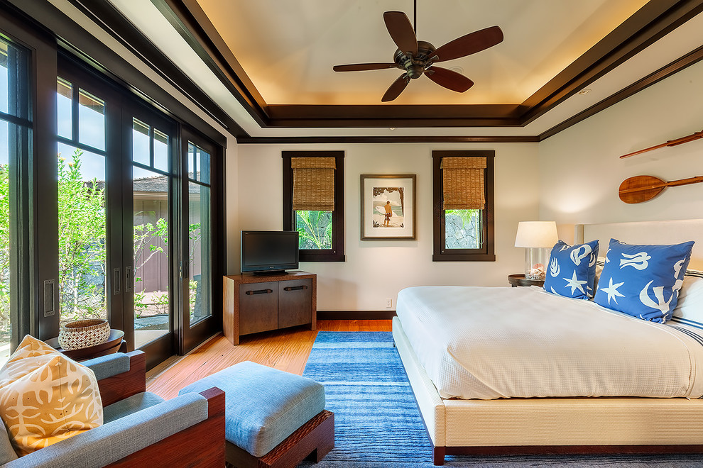 Maritimes Gästezimmer mit weißer Wandfarbe und braunem Holzboden in Hawaii