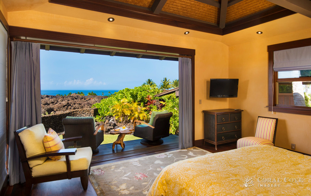 Inspiration for a large tropical guest dark wood floor bedroom remodel in Hawaii with yellow walls