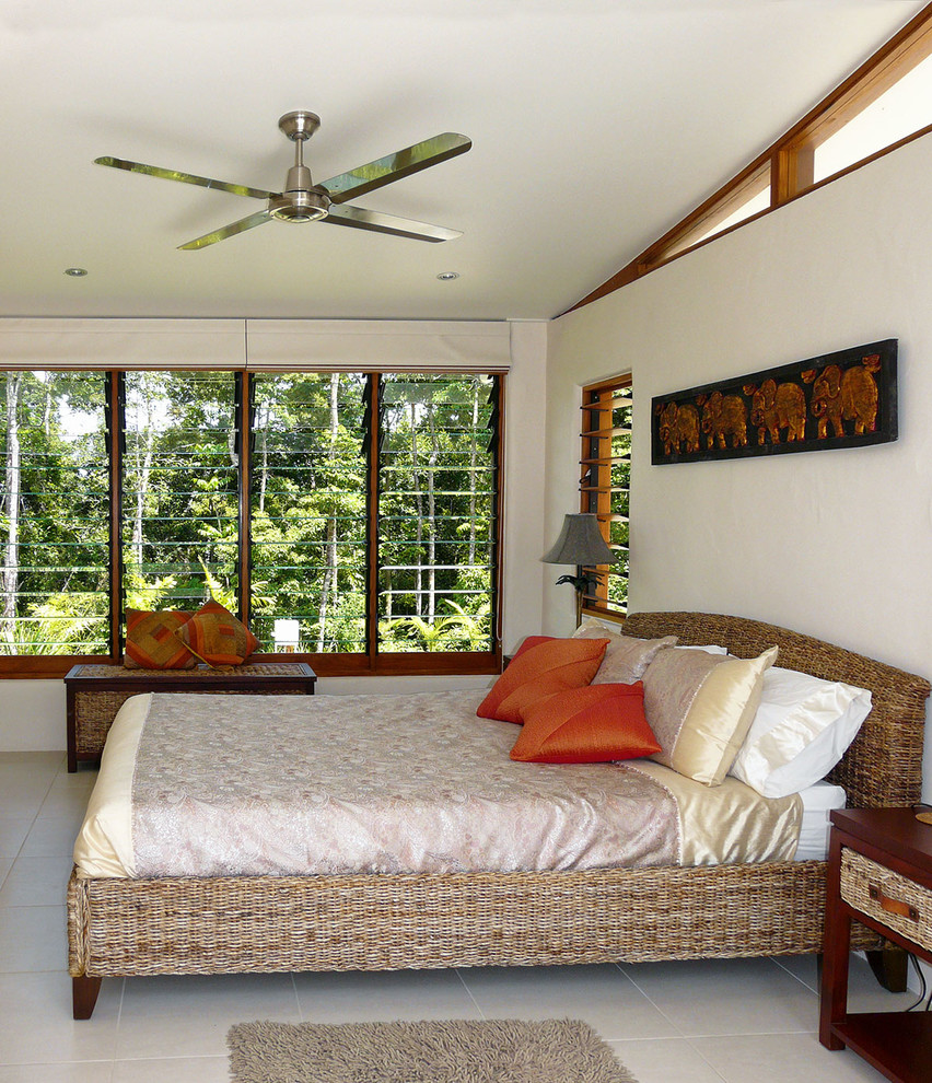 Ejemplo de dormitorio principal tropical de tamaño medio con suelo de baldosas de porcelana