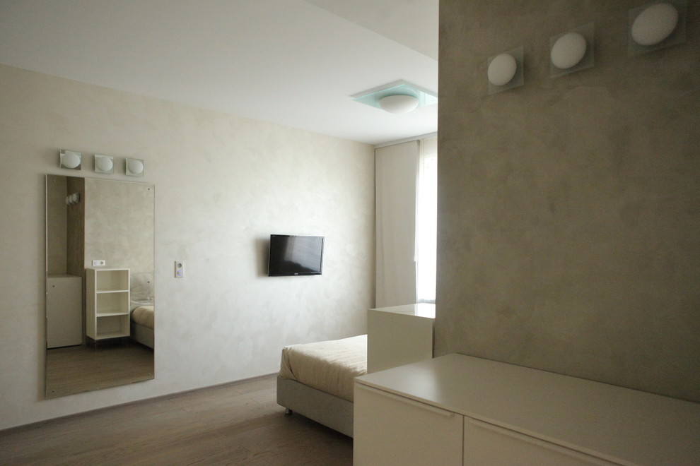 Modernes Schlafzimmer mit beiger Wandfarbe und braunem Holzboden in Alicante-Costa Blanca