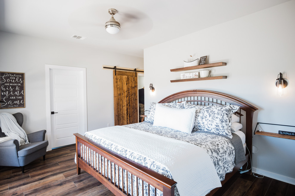 Imagen de dormitorio principal de estilo de casa de campo de tamaño medio con paredes grises, suelo de madera en tonos medios y suelo marrón