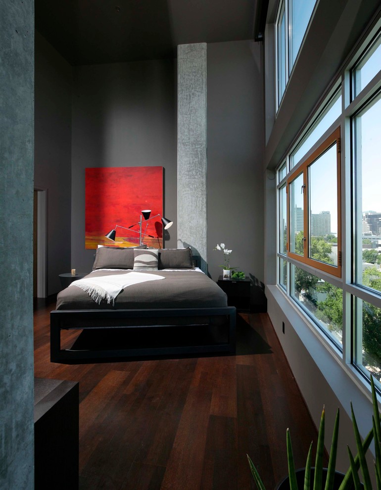 Ispirazione per una camera da letto moderna con pareti grigie e parquet scuro