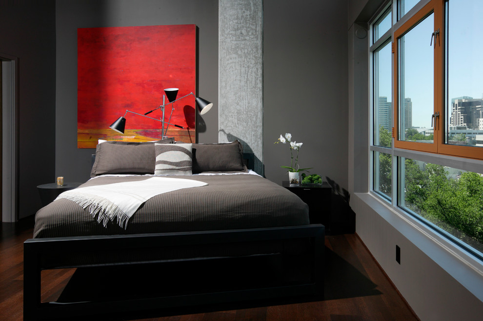 Diseño de dormitorio minimalista con paredes grises y suelo de madera oscura