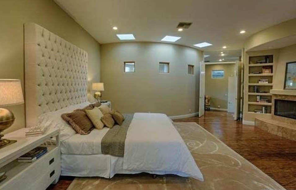 Foto di una grande camera matrimoniale american style con pareti beige e camino classico