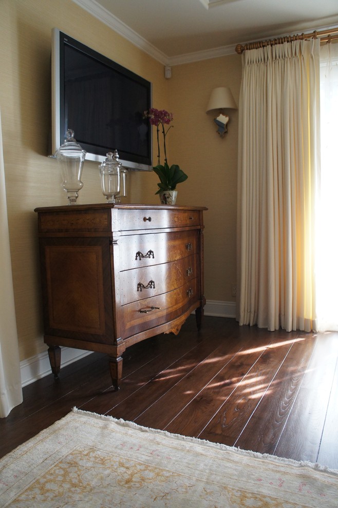 Klassisches Gästezimmer ohne Kamin mit gelber Wandfarbe und braunem Holzboden in Los Angeles